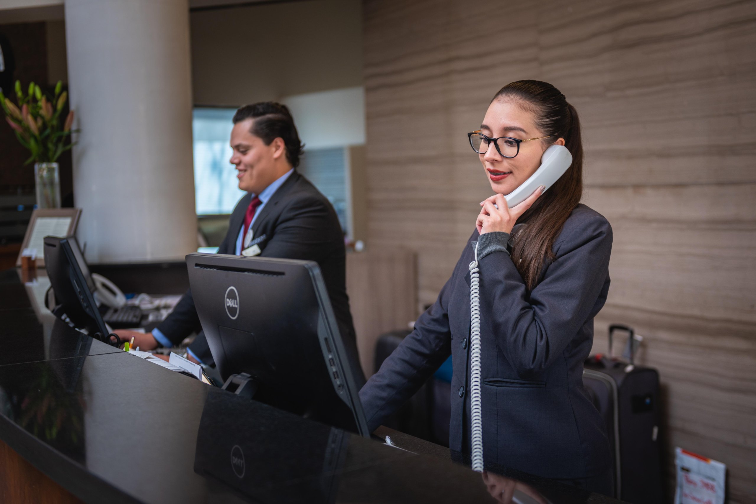 Hotel front desk receptionist checking in a guest